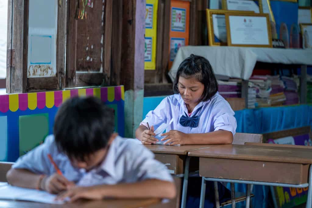 Asian elementary students in uniform studying together at classroom,Education,Student,People concept.